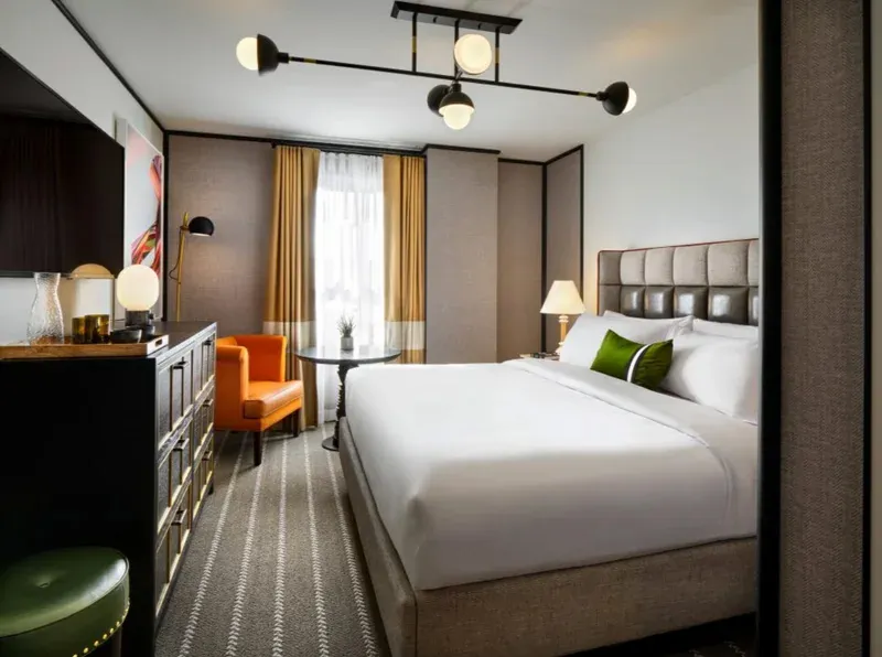 A king room at 21c Museum Hotel St. Louis with contemporary art, warm lighting, and modern furnishings