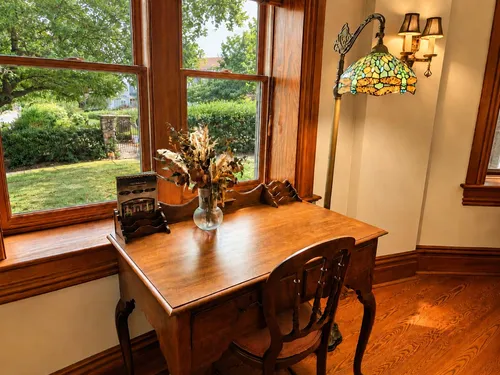 Antique writing desk with Tiffany dragonfly lamp and secret garden view
