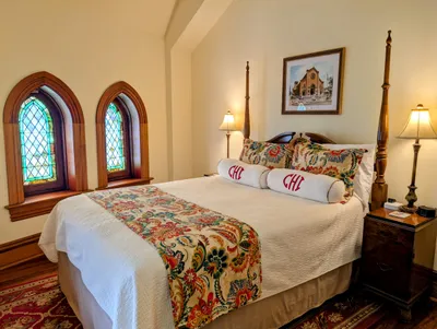 The Hill Suite picture of queen bed with stained glass windows