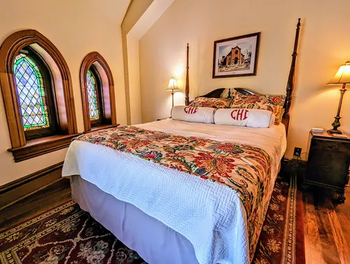 The Hill Suite picture of queen bed with stained glass windows