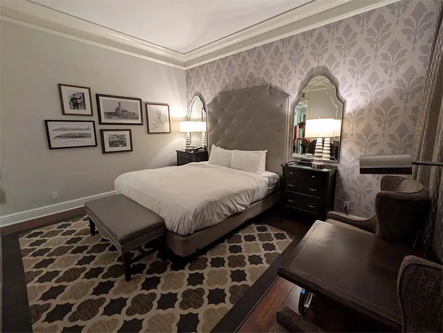 A king suite at St. Louis Union Station Hotel with period decor, historic rail photographs, and a tufted headboard